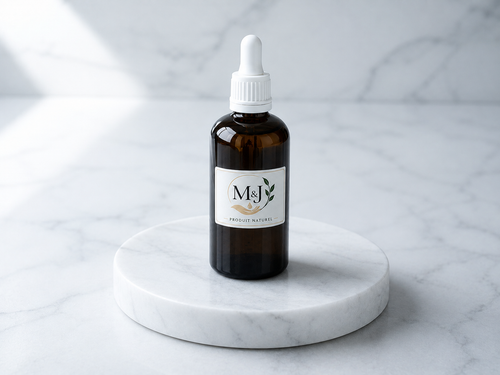 Huile de nigelle M&J, flacon compte-gouttes sur socle de marbre blanc